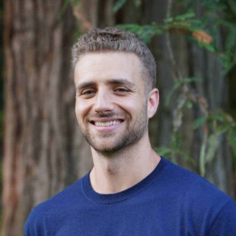 Riley_Hawkins Chief Strategy Officer for Evisort seen in a dark blue color round neck tshirt